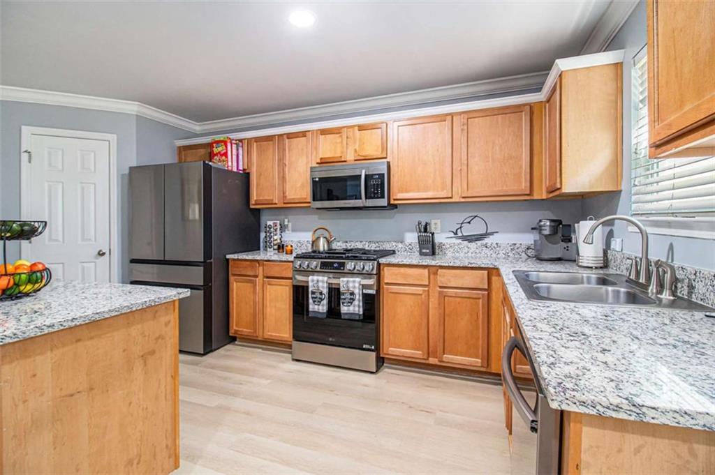 550 Windsor Way Fairburn, GA 30213 - Photo 11 of 28 a kitchen with granite countertop a refrigerator stove top oven and sink