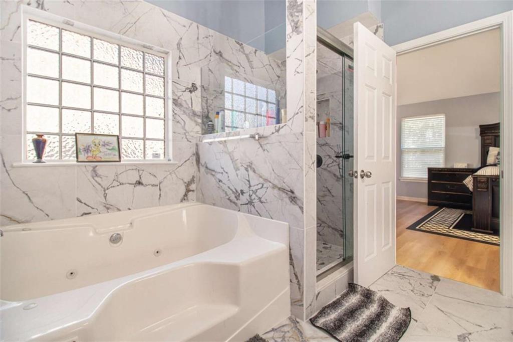 550 Windsor Way Fairburn, GA 30213 - Photo 17 of 28 a bathroom with a bathtub and a shower