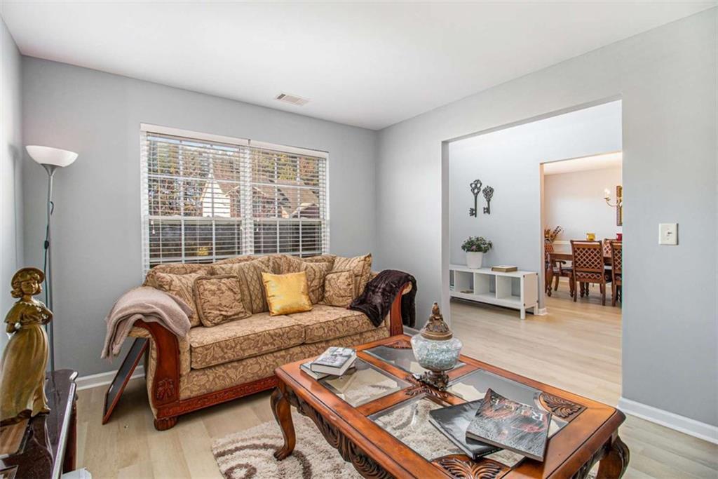 550 Windsor Way Fairburn, GA 30213 - Photo 7 of 28 a living room with furniture and a window with wooden floor