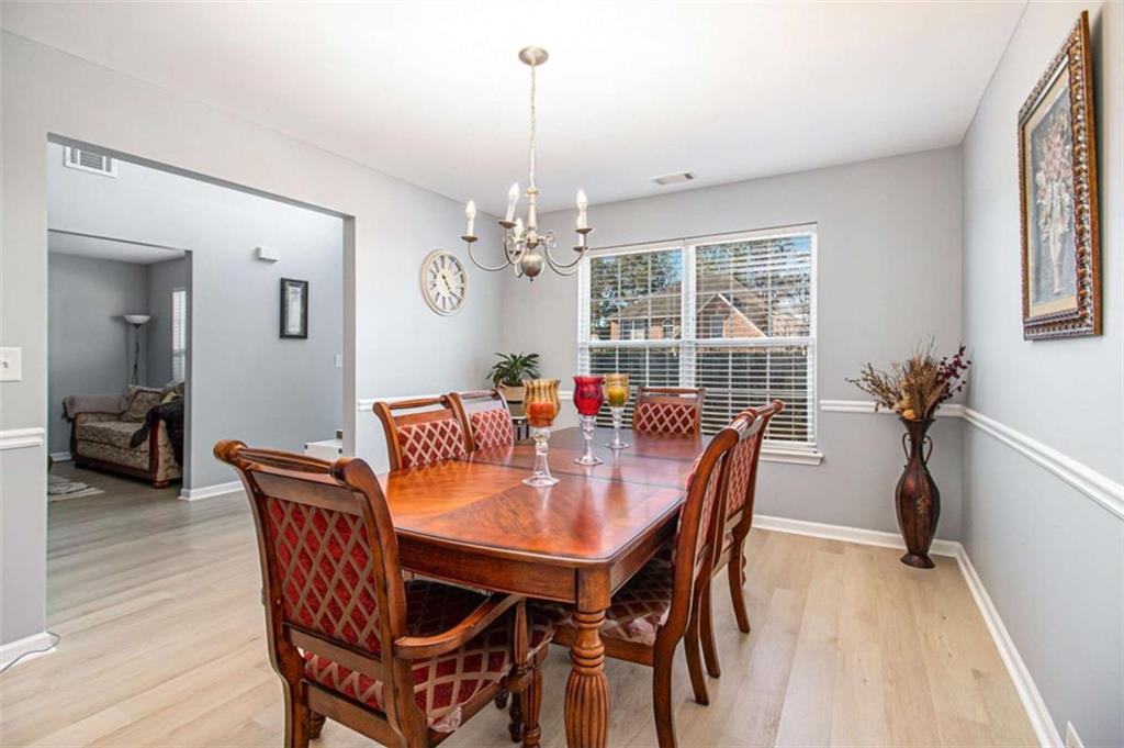 550 Windsor Way Fairburn, GA 30213 - Photo 8 of 28 a dining room with furniture a chandelier and wooden floor