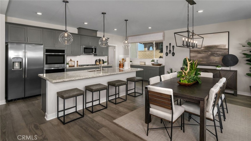 2395 Huron Road Rialto, CA 92377 - Photo 3 of 17 a kitchen with stainless steel appliances a dining table chairs refrigerator and microwave