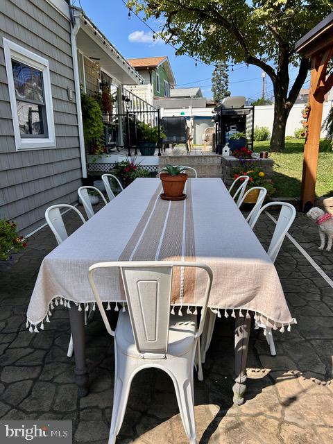 9203 Burbank Road Philadelphia, PA 19115 - Photo 60 of 62 a view of a patio with table and chairs under an umbrella with a barbeque