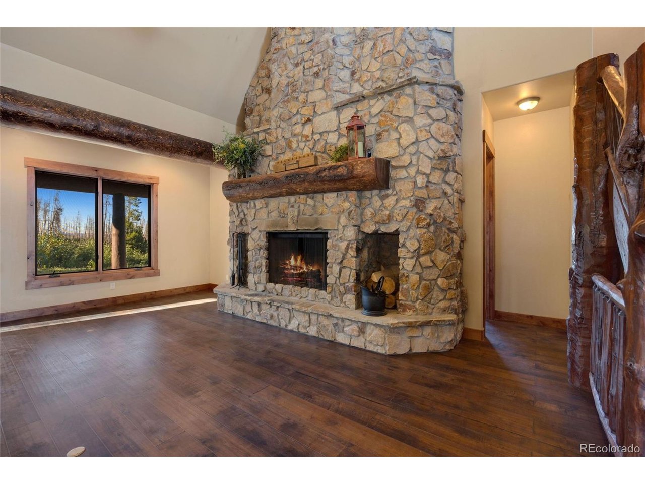 5200 Jackson Road Walden, CO 80480 - Photo 17 of 40 Custom floor to ceiling fireplace, surrounded by large windows, complete with logs and stone harvested from the property