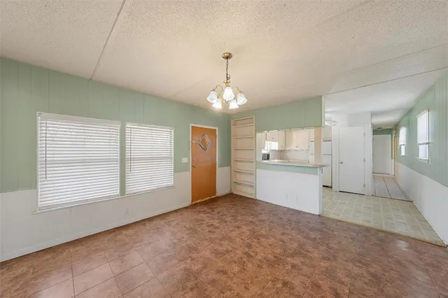 a view of an empty room with window and cabinet