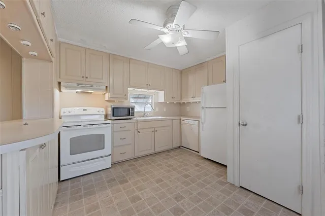 a kitchen with white cabinets and white appliances
