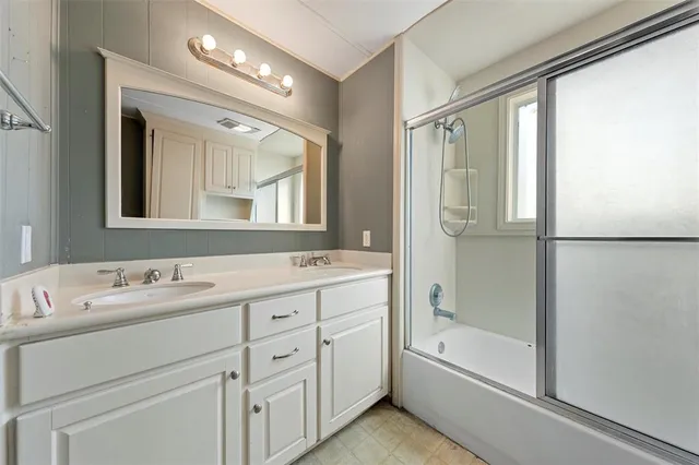 a bathroom with a tub sink shower and mirror