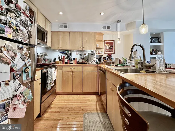 a kitchen with kitchen island granite countertop a sink stainless steel appliances and cabinets