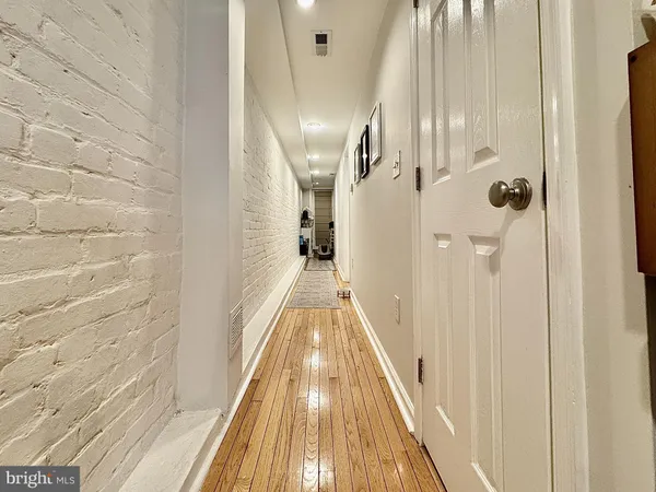 a view of a hallway with wooden floor