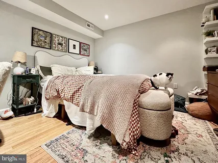 a bedroom with a bed and wooden floor