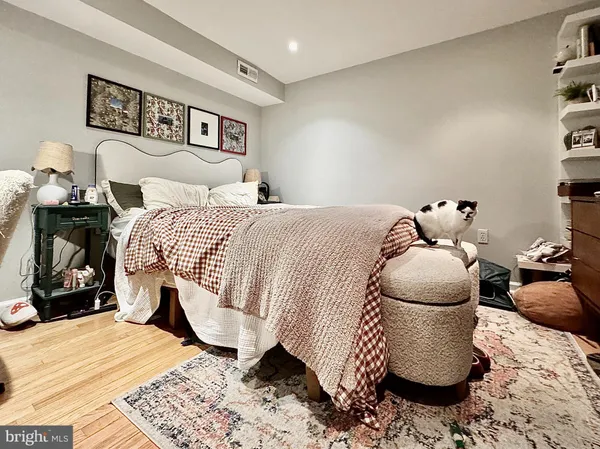 a bedroom with a bed and wooden floor