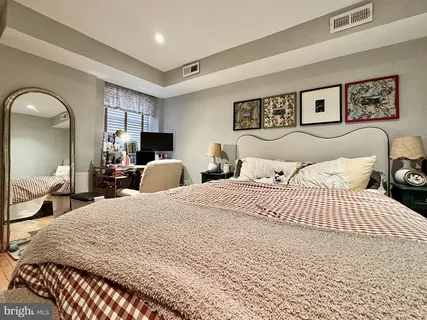 a bedroom with a large bed and a chandelier
