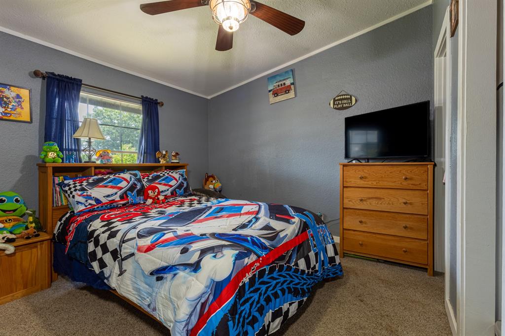 75 Southern Road Mineral Wells, TX 76067 - Photo 23 of 31 a bedroom with a bed and a flat tv screen on dresser