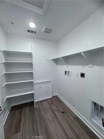 a view of storage and utility room with wooden floor