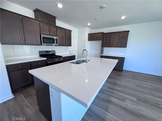 a kitchen with stainless steel appliances a microwave sink refrigerator and cabinets