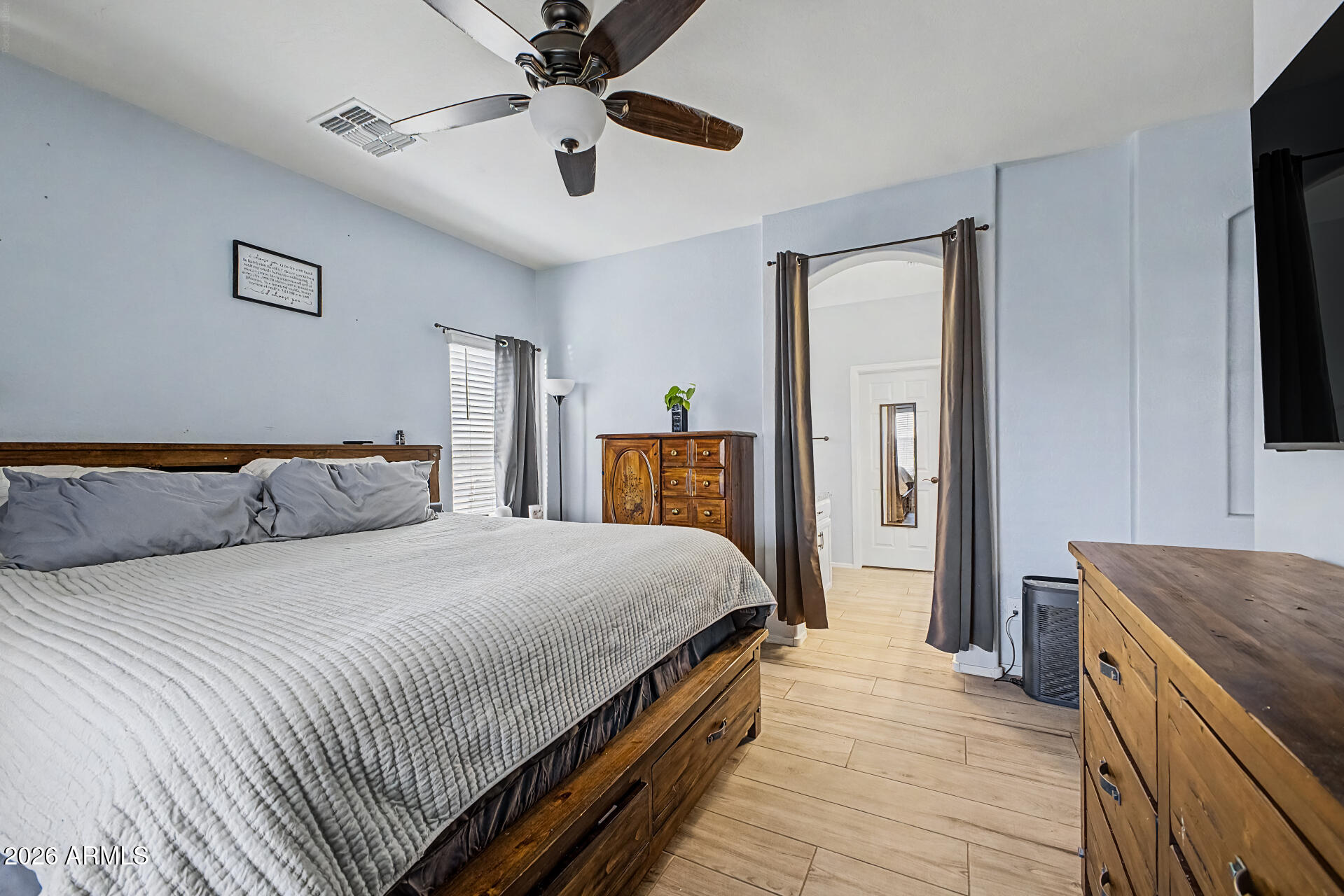 16719 West Rowel Road Surprise, AZ 85387 - Photo 12 of 28 a spacious bedroom with a bed and a chandelier