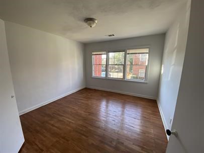1915 13th Street Columbus, GA 31906 - Photo 3 of 5 an empty room with wooden floor and windows