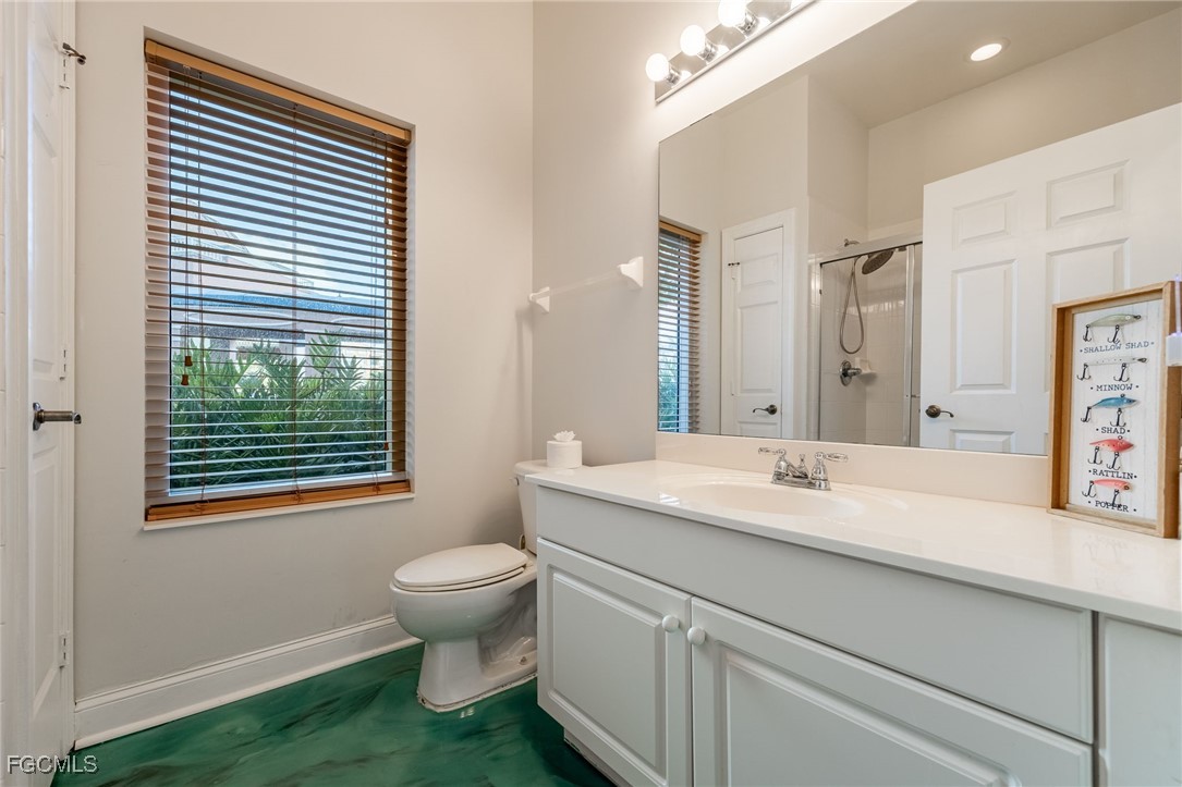 2743 First Street, Unit 304 Fort Myers, FL 33916 - Photo 28 of 50 a bathroom with a granite countertop toilet a sink a mirror and a window