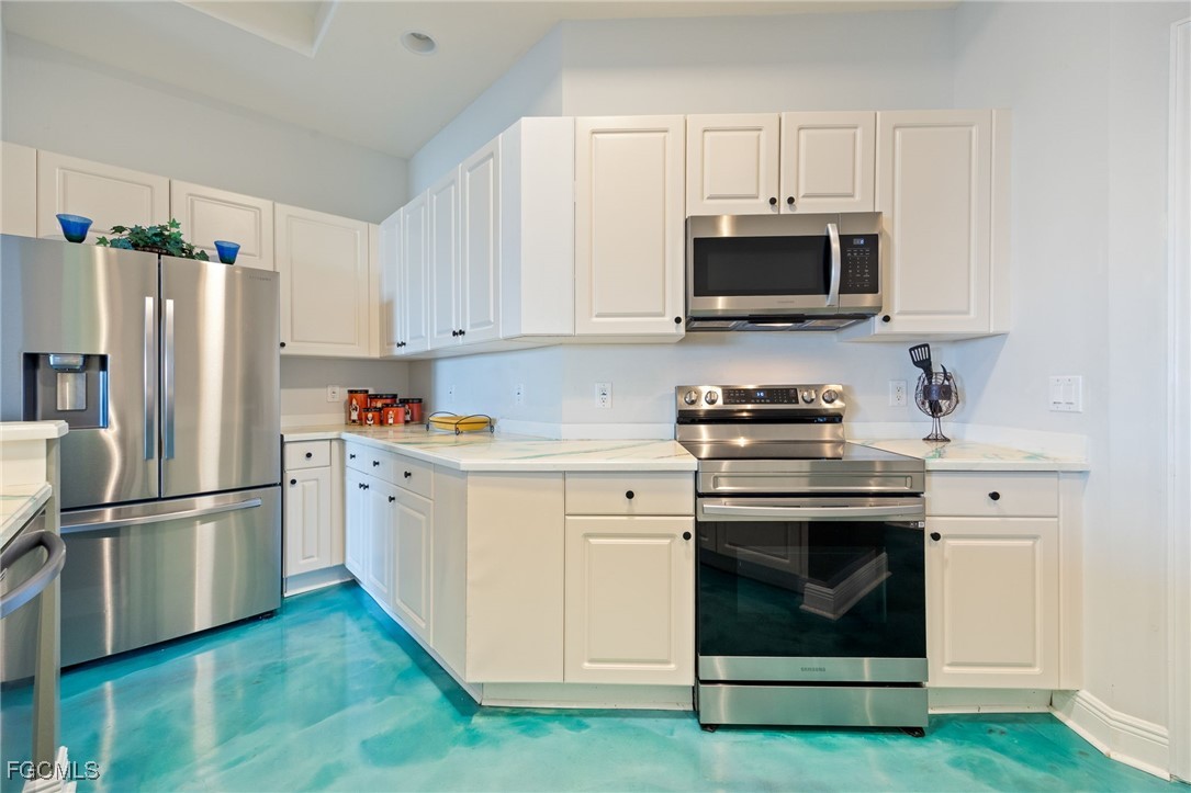 2743 First Street, Unit 304 Fort Myers, FL 33916 - Photo 4 of 50 a kitchen with white cabinets and stainless steel appliances