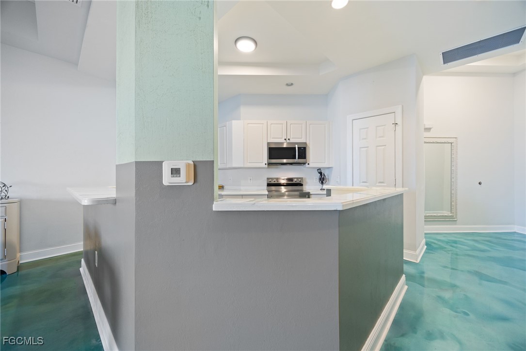 2743 First Street, Unit 304 Fort Myers, FL 33916 - Photo 7 of 50 a kitchen with kitchen island a sink appliances and cabinets