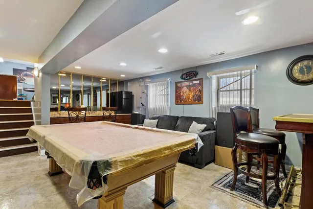 a room with furniture pool table and windows