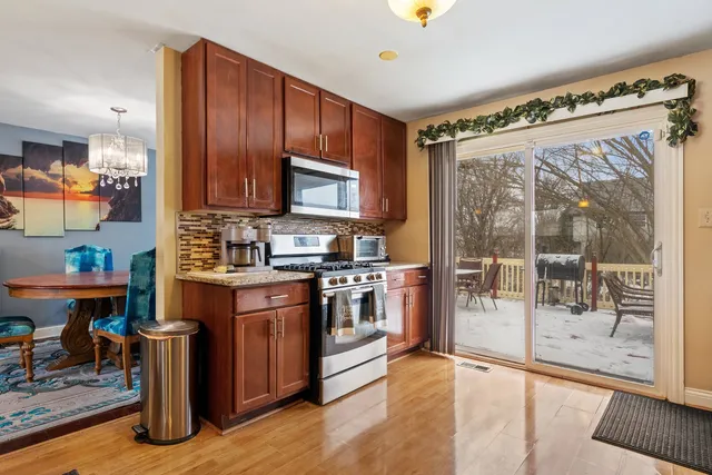 a kitchen with stainless steel appliances granite countertop a stove top oven a sink and a dining table with granite countertops