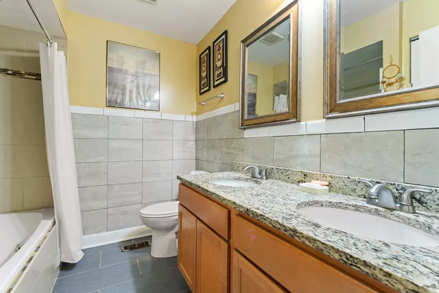 a bathroom with a granite countertop sink toilet and shower