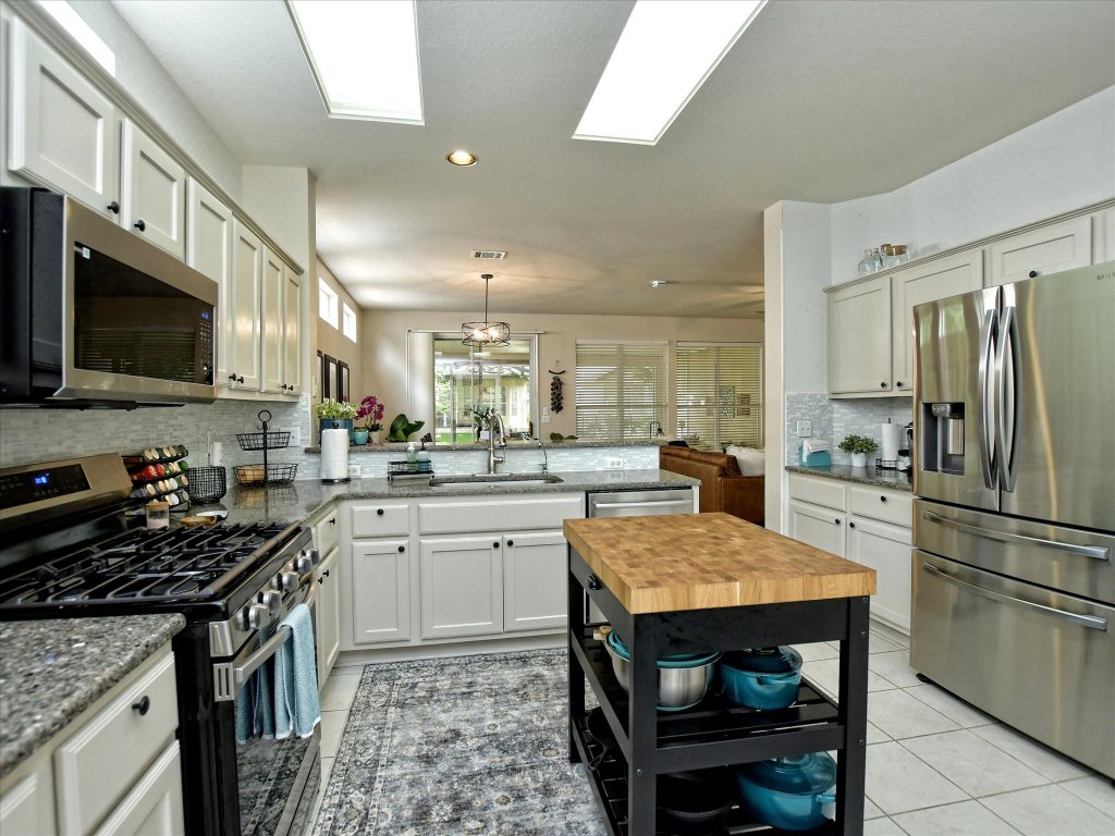116 Running Water Street Georgetown, TX 78633 - Photo 11 of 25 a kitchen with a sink a stove a refrigerator and a oven