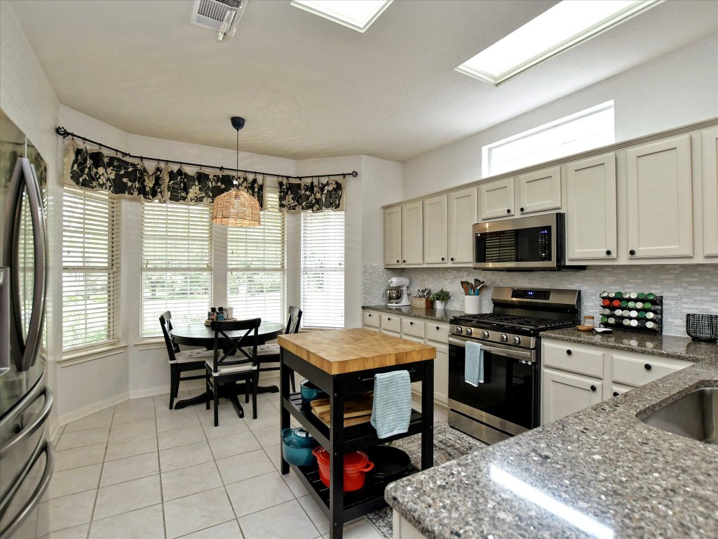 116 Running Water Street Georgetown, TX 78633 - Photo 12 of 25 a kitchen with a stove a sink and a refrigerator