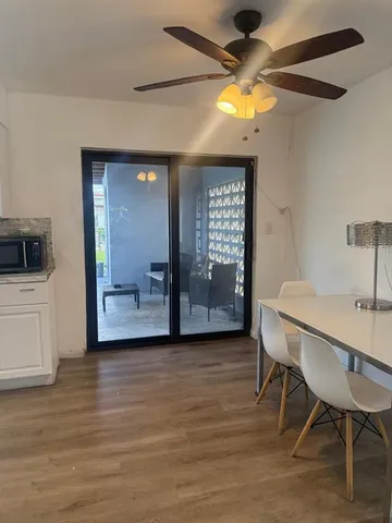 a view of a livingroom with a chair and a chandelier fan