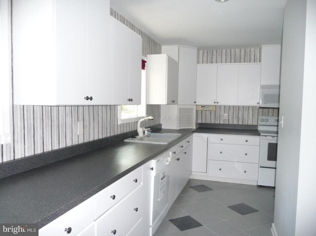275 Windjammer Road Ocean Pines, MD 21811 - Photo 18 of 20 a kitchen with granite countertop white cabinets and sink
