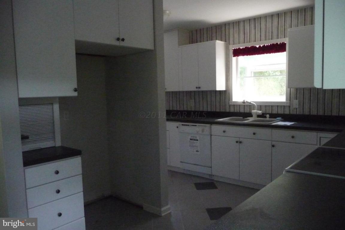 275 Windjammer Road Ocean Pines, MD 21811 - Photo 19 of 20 a kitchen with granite countertop white cabinets and window