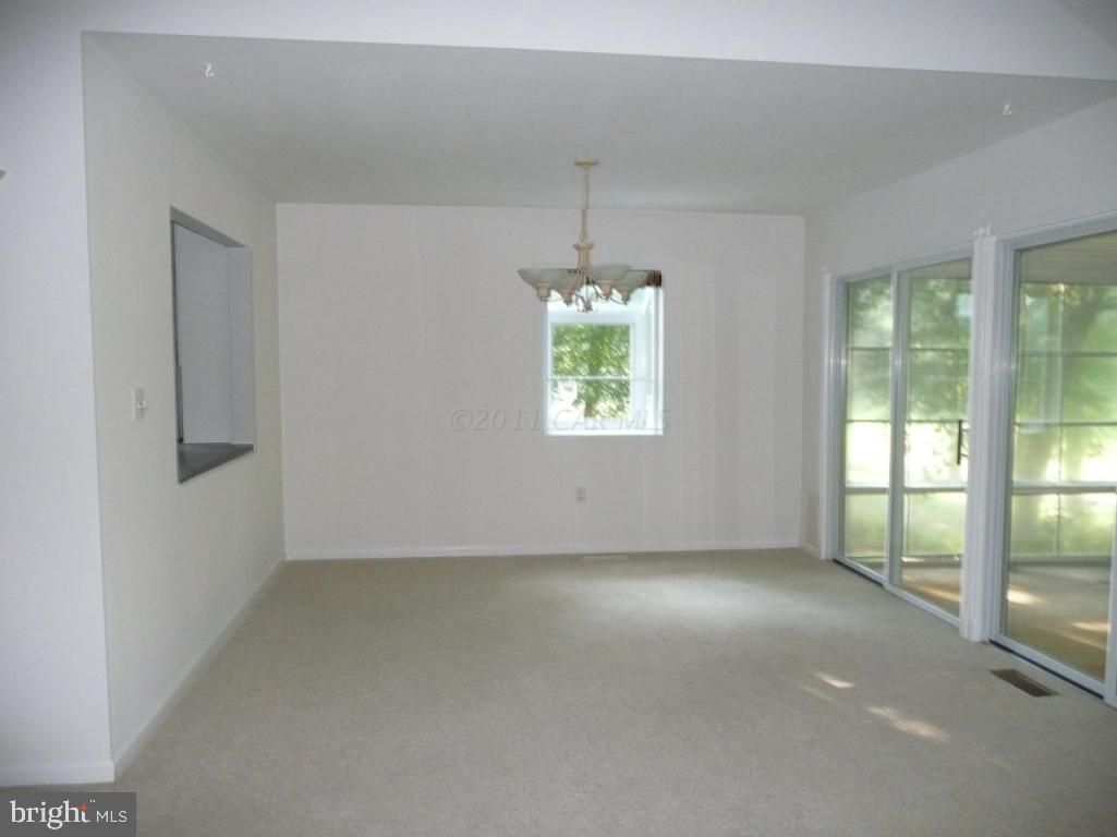 275 Windjammer Road Ocean Pines, MD 21811 - Photo 6 of 20 an empty room with a windows and chandelier