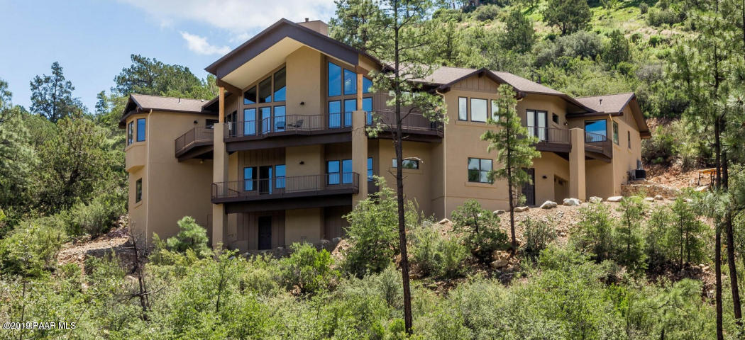 a front view of a house with balcony and trees