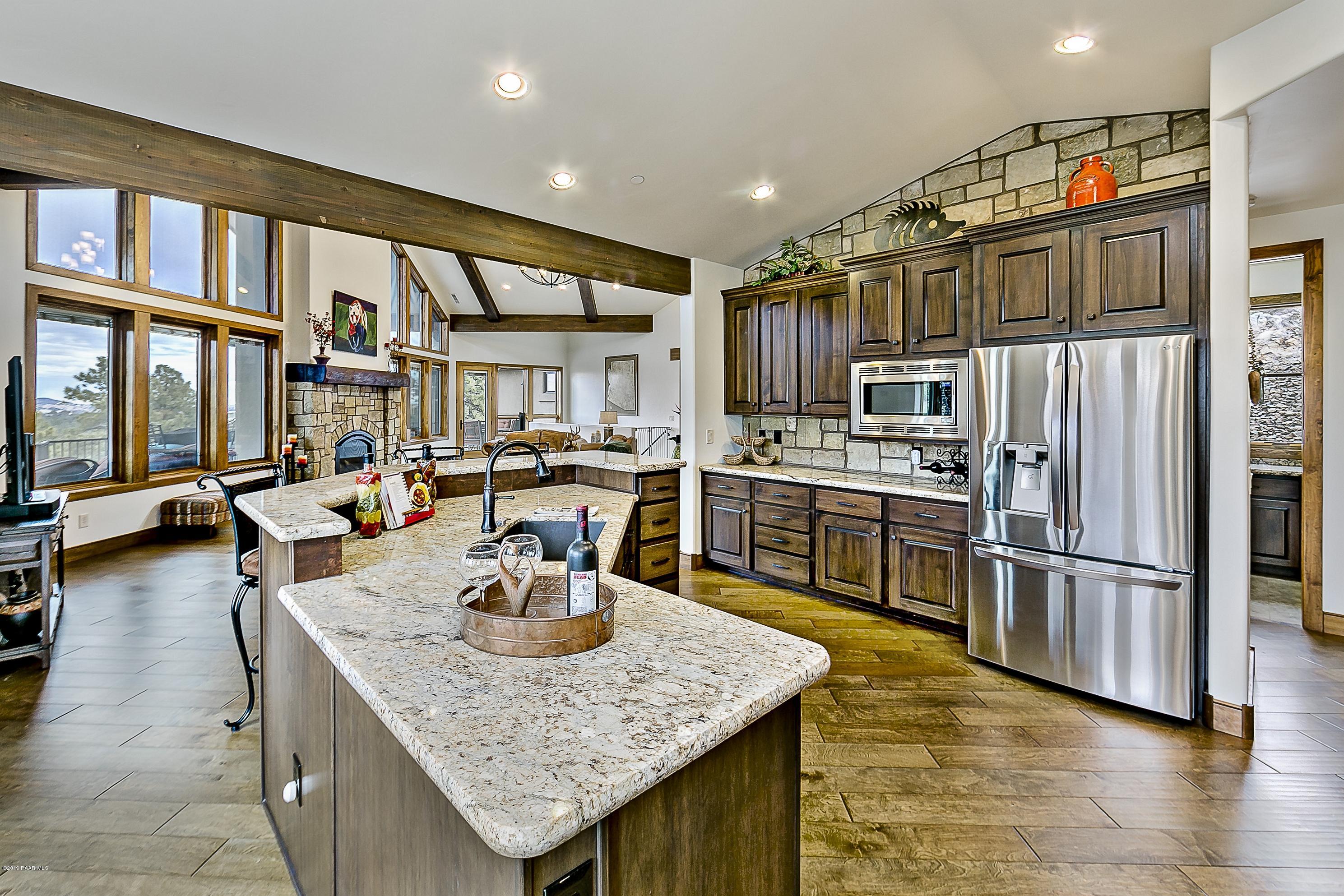 1340 East Valley View Road Prescott, AZ 86303 - Photo 9 of 33 a kitchen with stainless steel appliances granite countertop a table chairs and a refrigerator