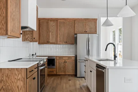 a kitchen with stainless steel appliances a sink cabinets and wooden floor