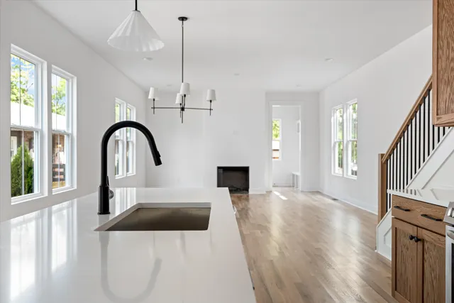 a view of a kitchen with a sink and dishwasher with wooden floor