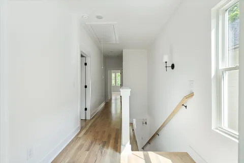a view of a hallway with wooden floor and staircase