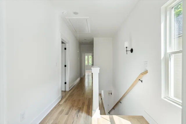 a view of a hallway with wooden floor and staircase