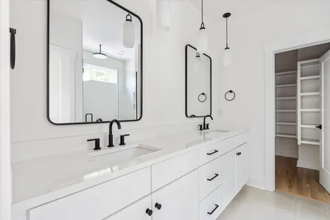 a bathroom with double vanity sink and a mirror