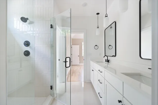 a spacious bathroom with a granite countertop sink a mirror a shower and a bathtub