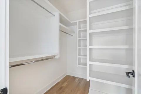 a view of walk in closet with empty racks