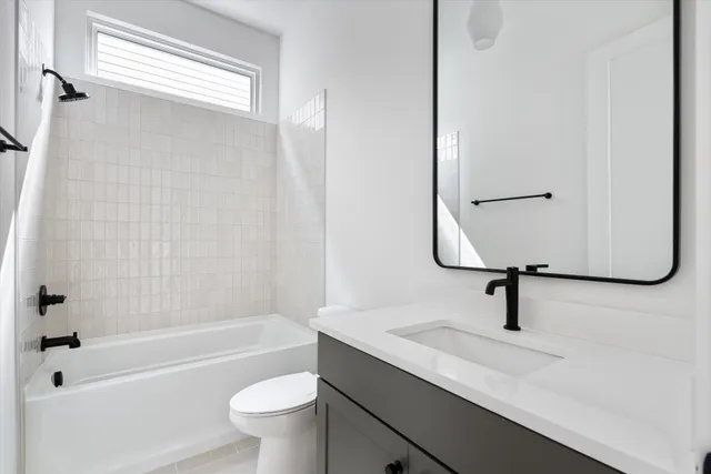 a bathroom with a sink a toilet a mirror and shower