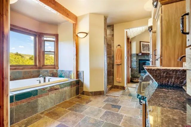 a spacious bathroom with a tub a double vanity sink a mirror and a shower