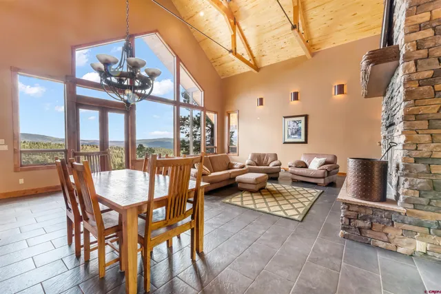a dining room with furniture and a floor to ceiling window
