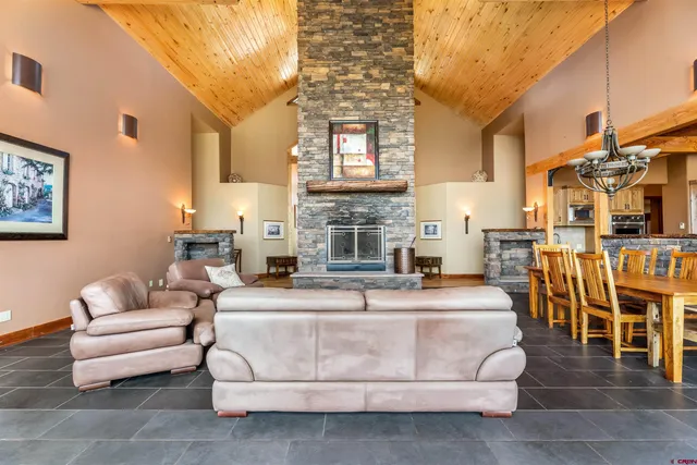 a living room with furniture a fireplace and a chandelier
