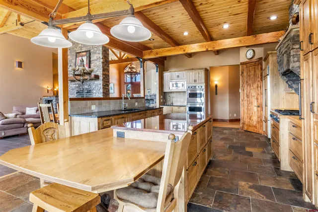 a dining room with stainless steel appliances kitchen island granite countertop a table and chairs in it