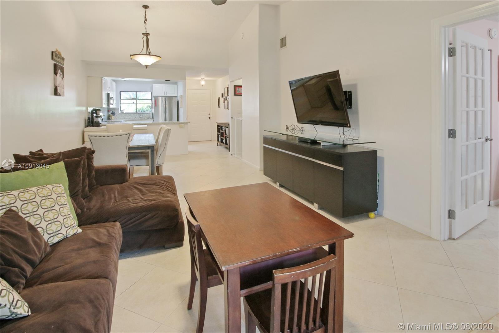 739 Banks Road Margate, FL 33063 - Photo 7 of 21 a living room with furniture a flat screen tv and kitchen view
