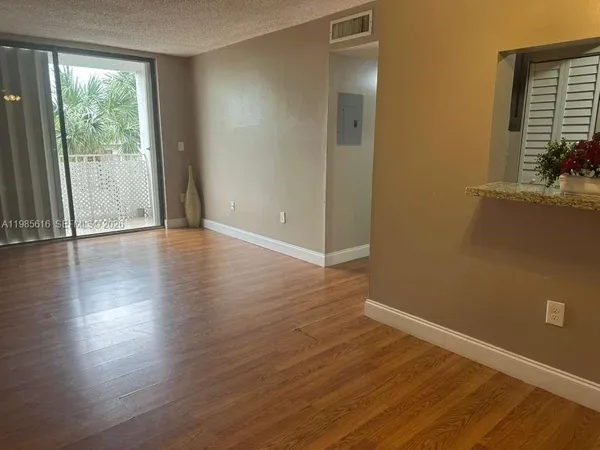 a view of an empty room with wooden floor