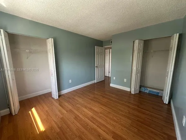 an empty room with wooden floor and closet