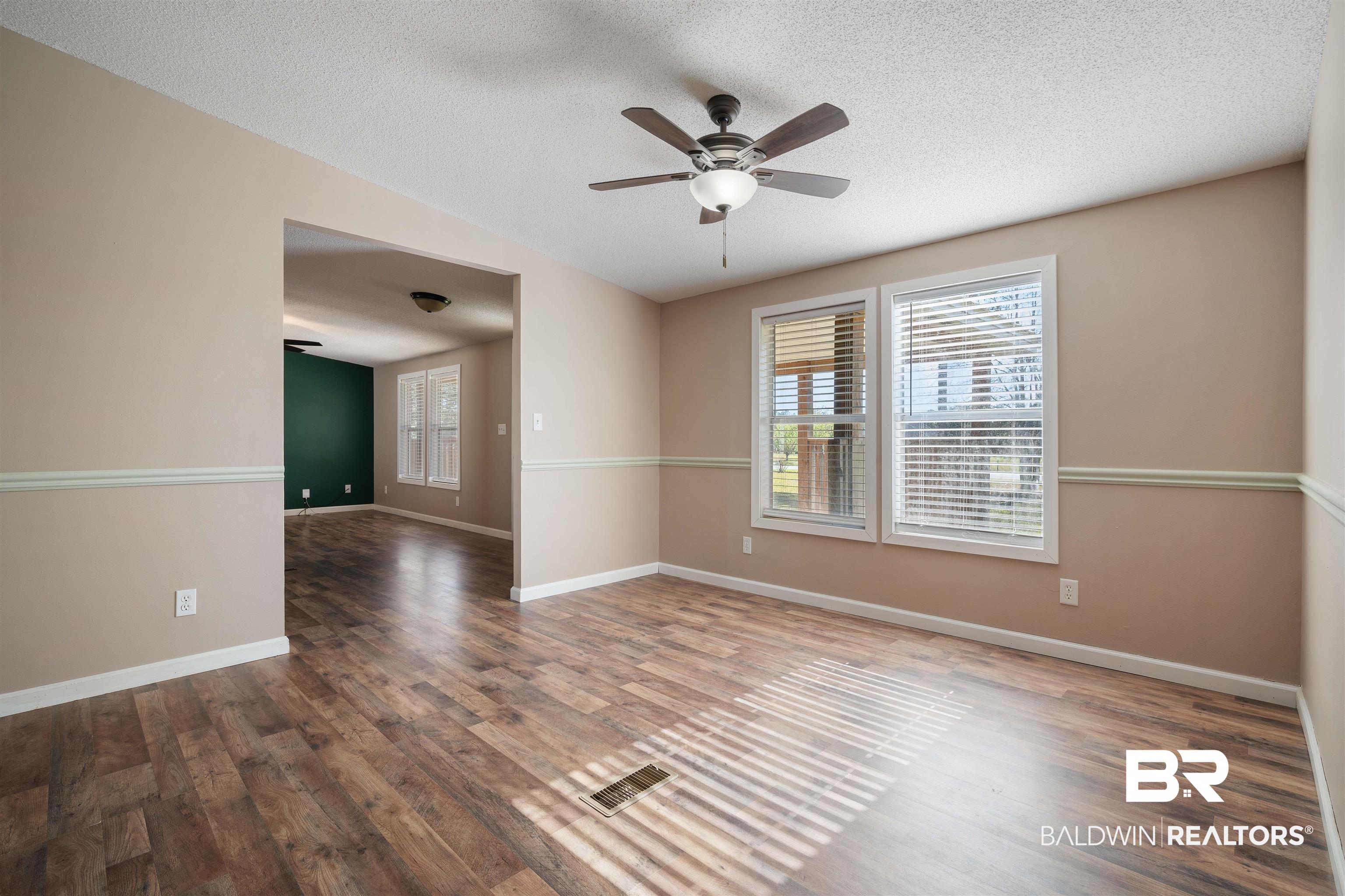 9011 Wilmer Georgetown Road Wilmer, AL 36587 - Photo 25 of 34 Unfurnished room with a ceiling fan, a wealth of natural light, wood finished floors, and visible vents
